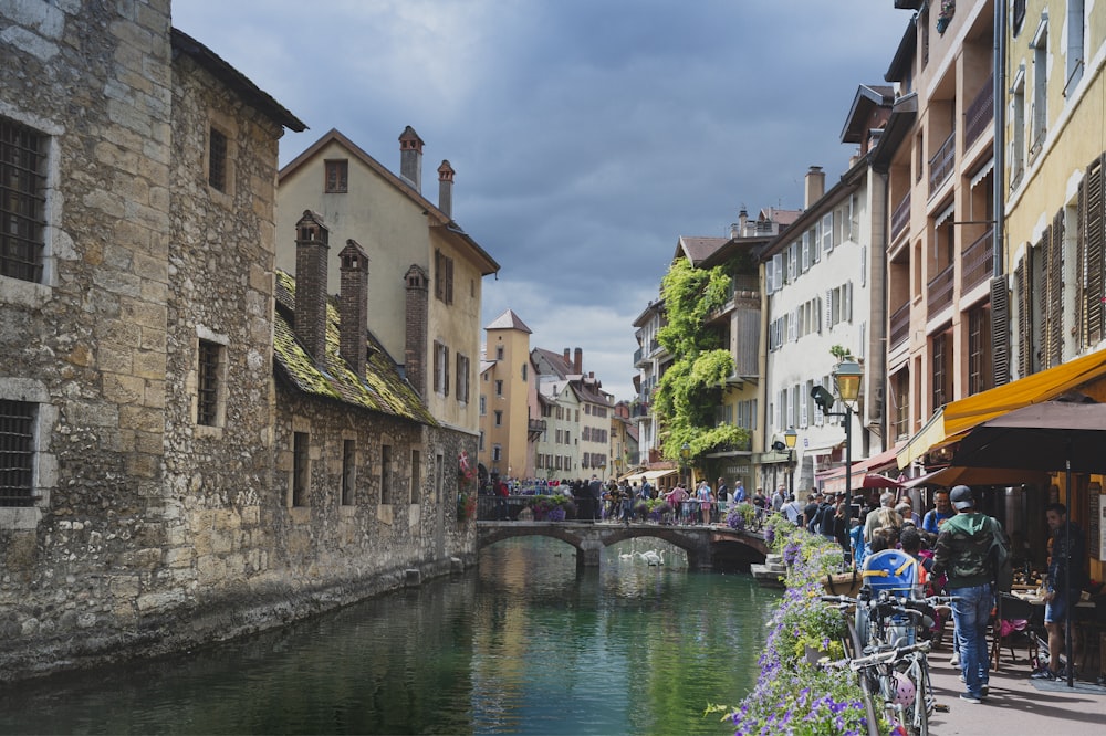 Menschen, die tagsüber auf dem Bürgersteig in der Nähe des Flusses spazieren gehen