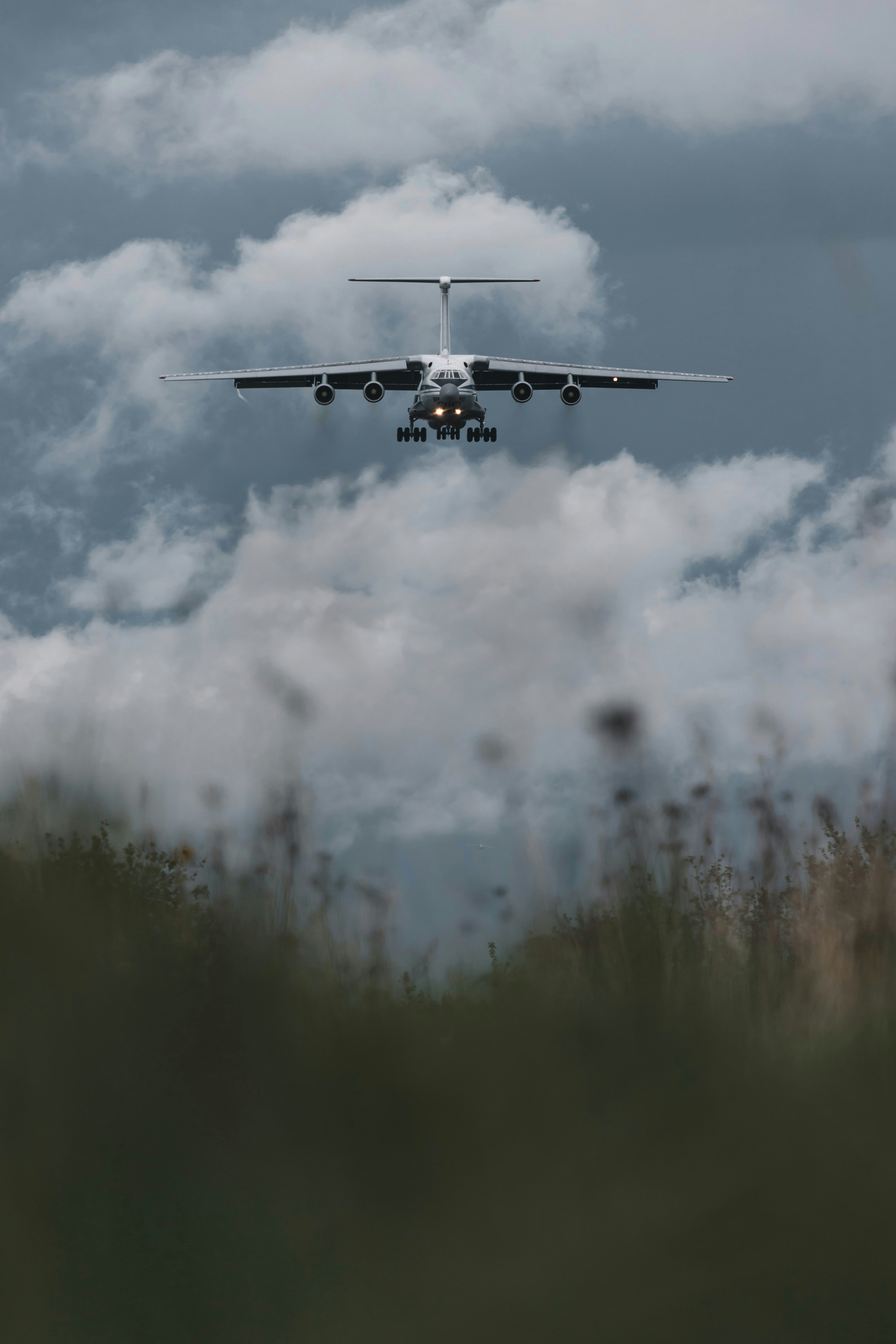 white and black airplane flying over green grass field during daytime