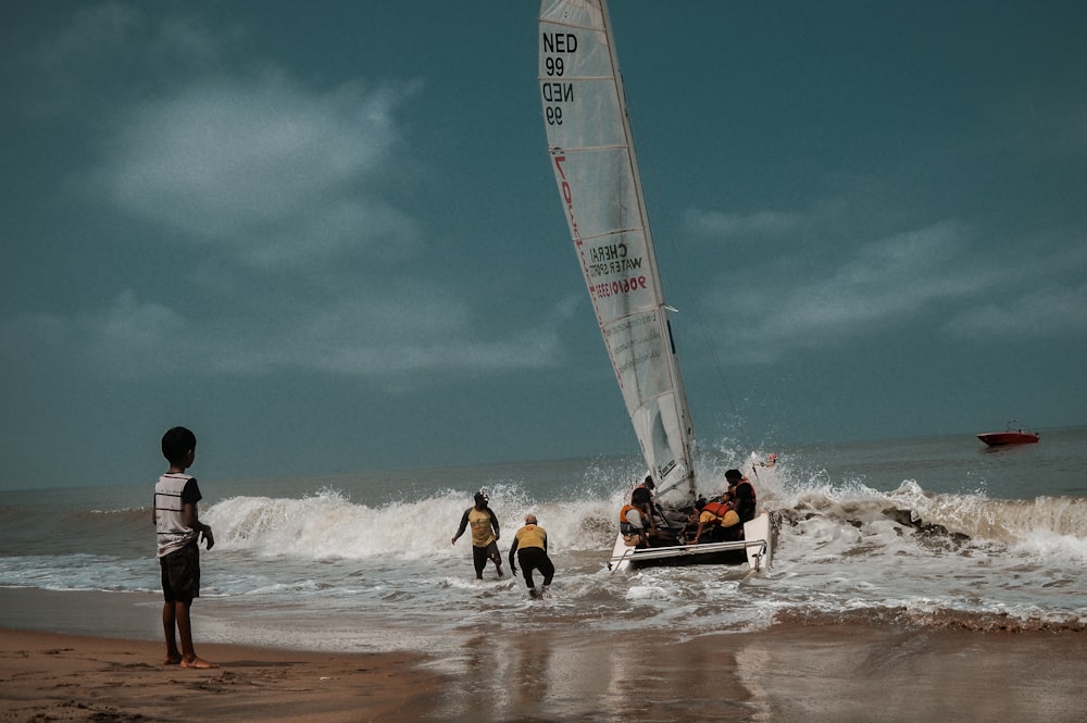 people riding on white and red sail boat on sea during daytime