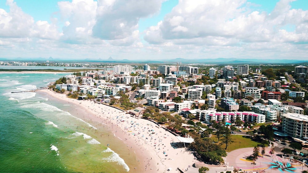 city buildings near body of water under white clouds and blue sky during daytime