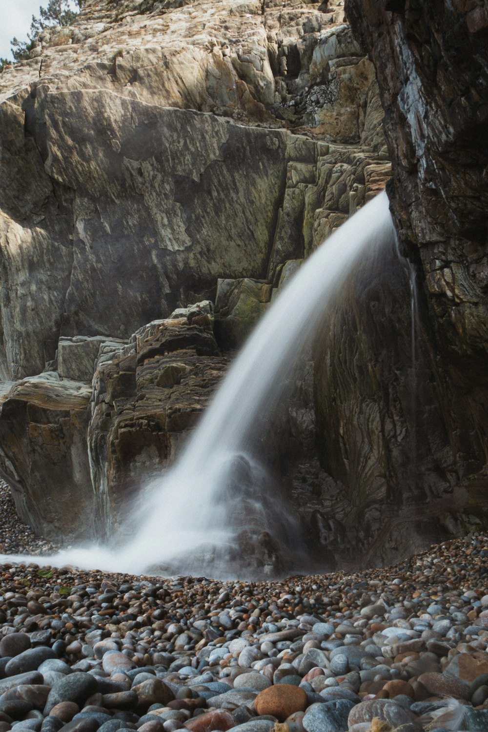 a small waterfall spewing water into a rocky area