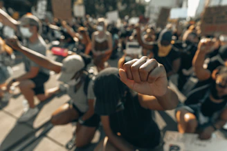 people in black shirts and black shorts sitting on bench during daytime