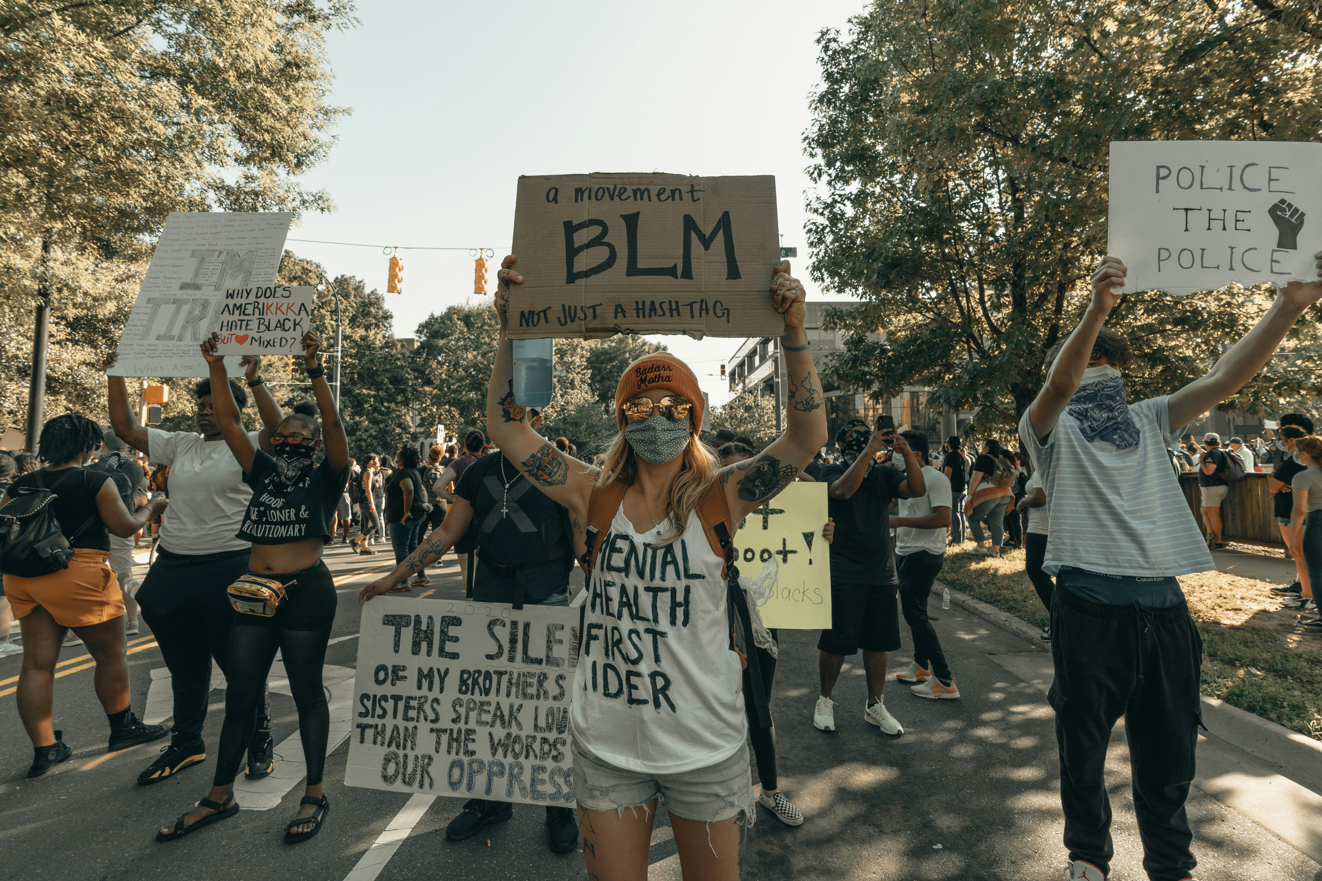 woman in white tank top holding white and black banner