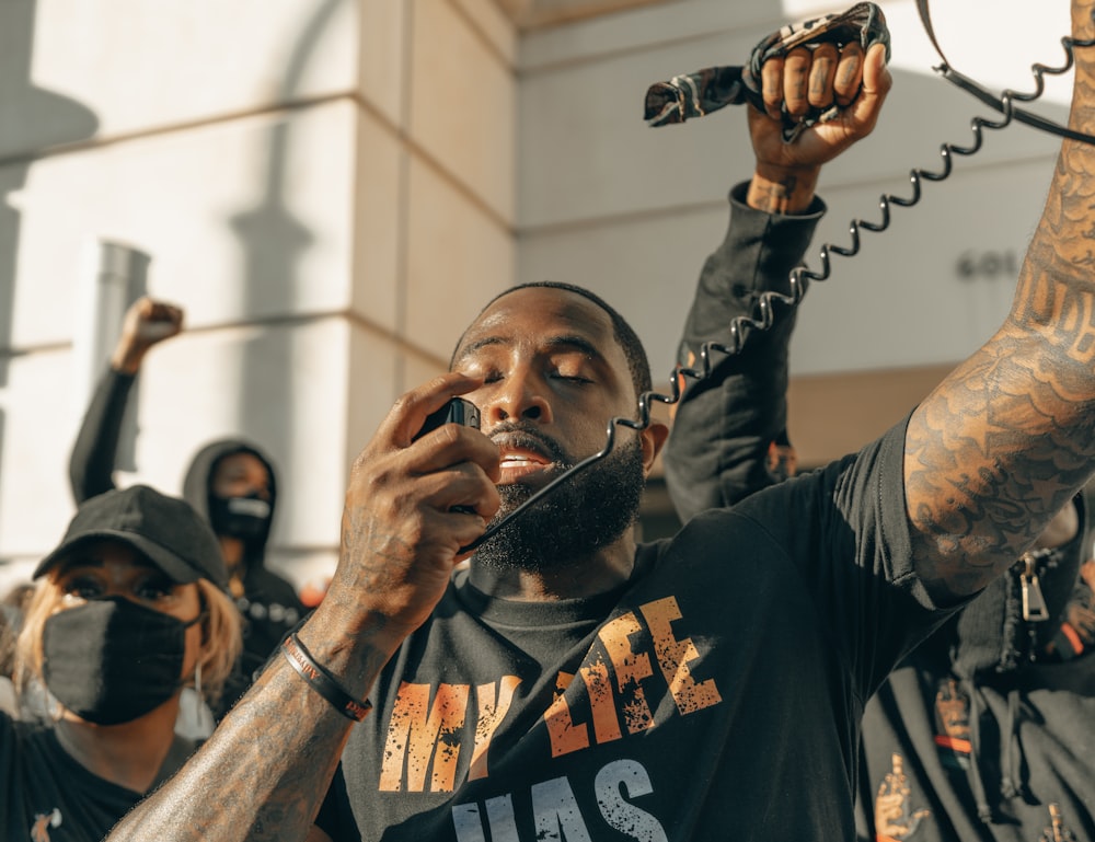 man in black crew neck t-shirt holding microphone