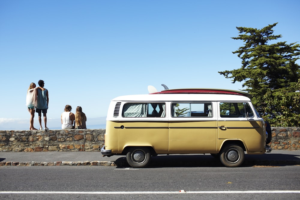 2 women standing beside yellow volkswagen t-1 van