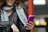 A stylish young woman holding her phone with a blush pink luméa case, smiling in natural light.