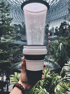 person holding white and black coffee cup