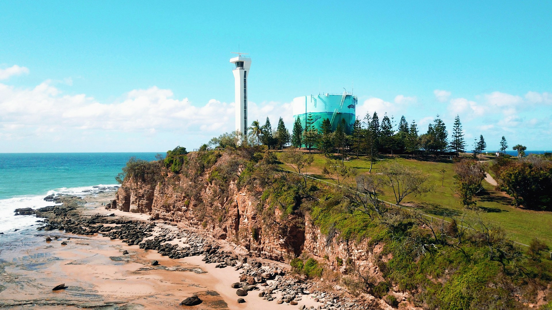 white concrete tower on brown rocky hill under blue sky during daytime