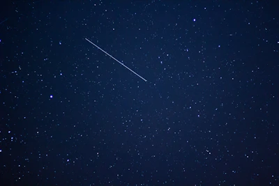 A brilliant meteor streaking across a star-studded sky.