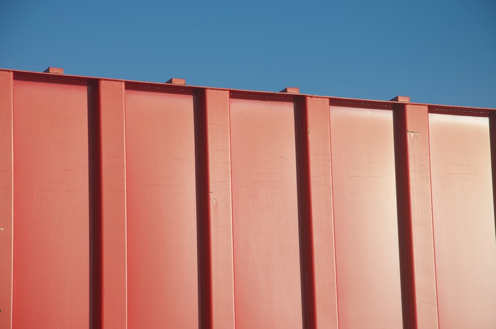 Puerta de acero rojo bajo el cielo azul durante el día