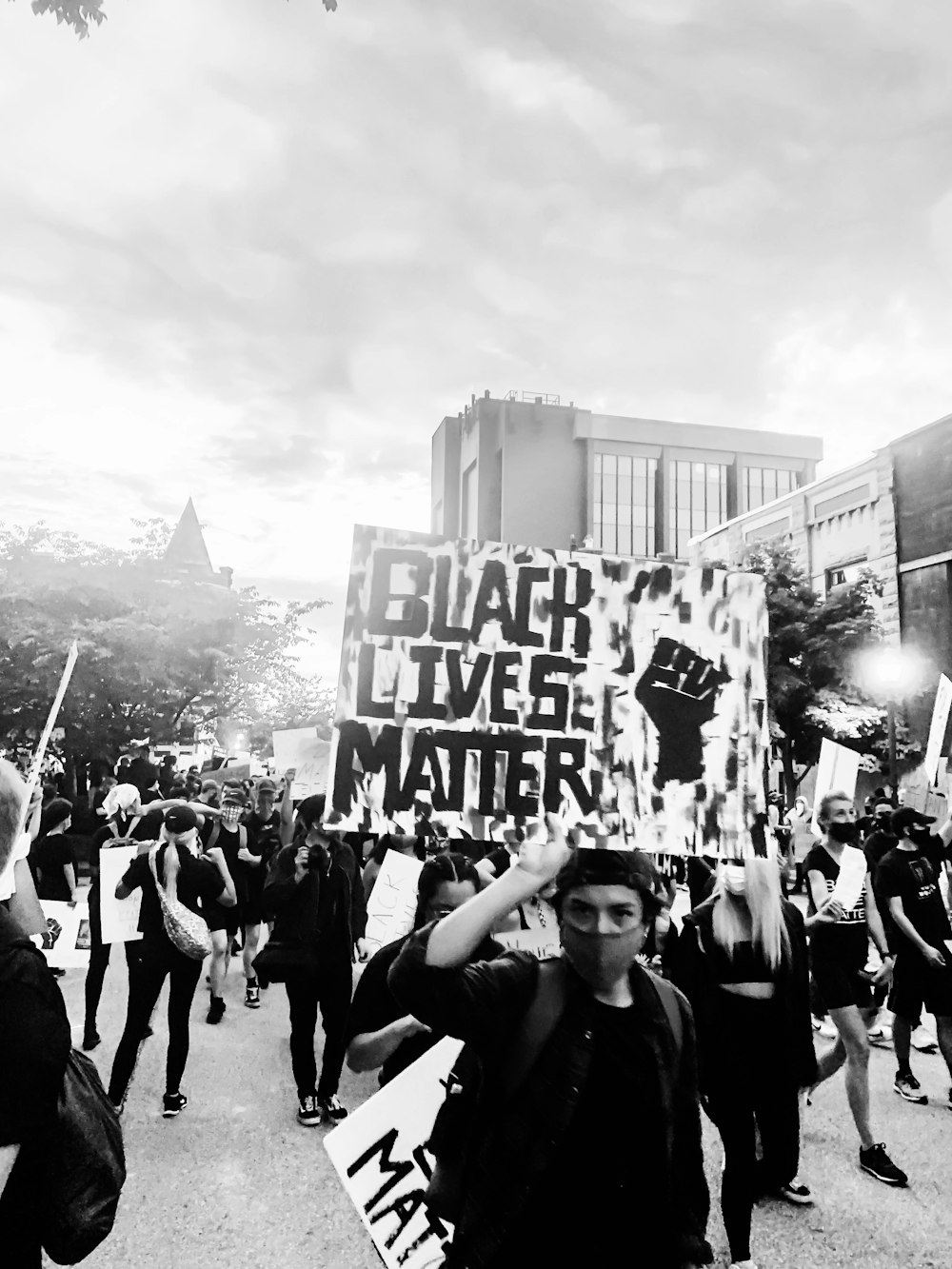 grayscale photo of people holding banner