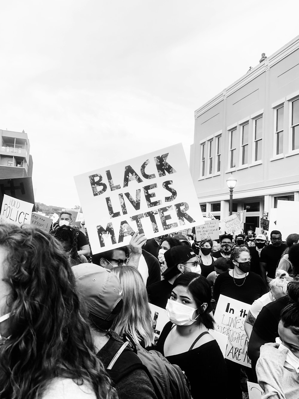 grayscale photo of people in front of building