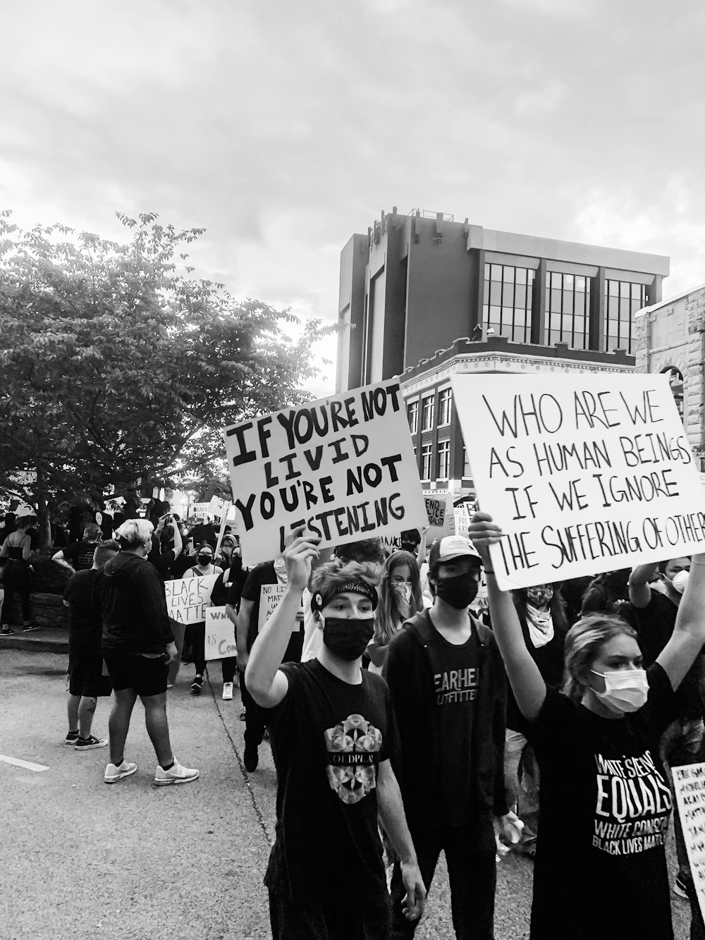 grayscale photo of people holding white and black signage