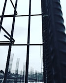 Metal rebar structures stand vertically, forming a framework against a pale sky. In the background, additional rebar formations are visible, likely part of a construction site. The image conveys a sense of industrial progress and development.