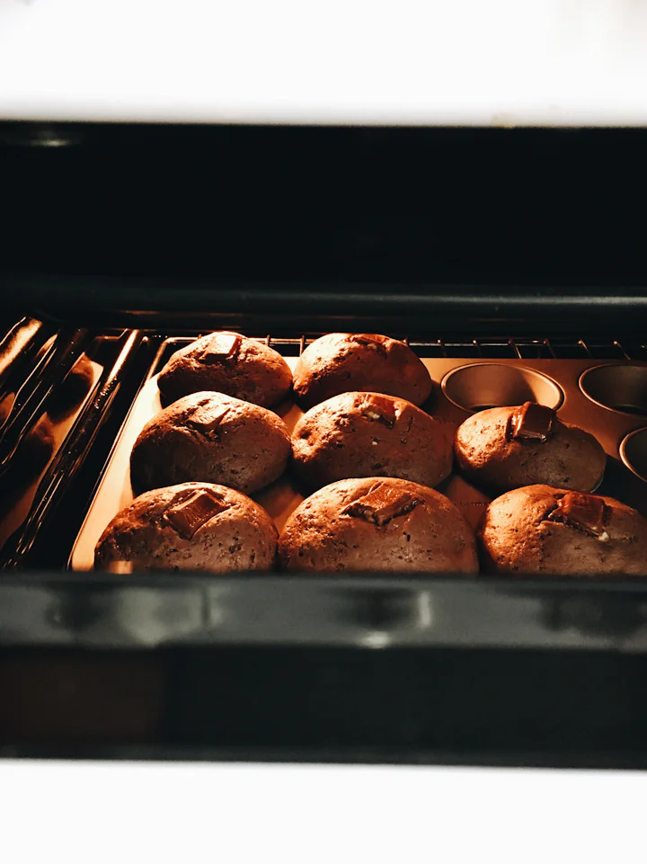 A close up of muffins baking in an oven