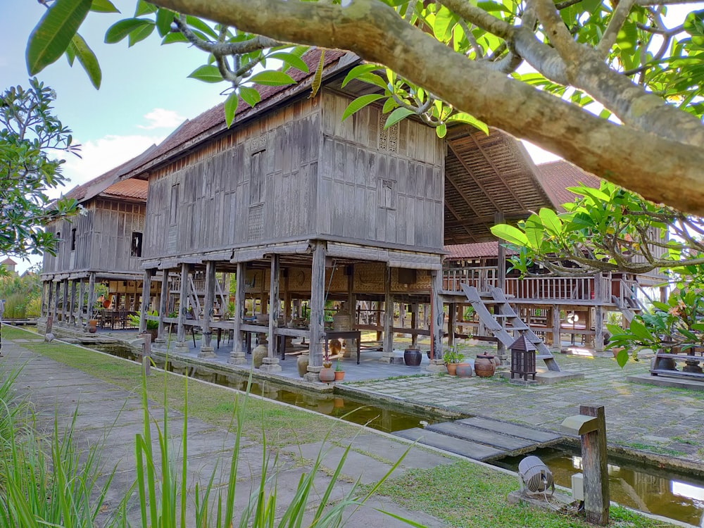 brown wooden house near green trees during daytime