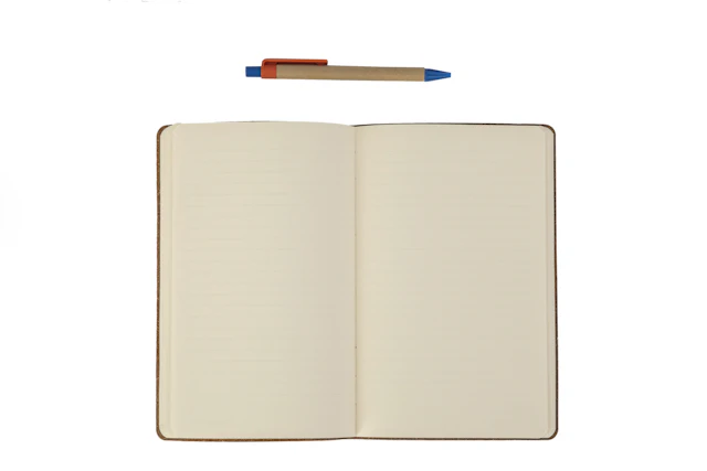 Cuaderno abierto con una pluma sobre la página