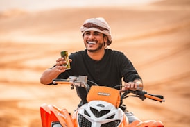 man in black crew neck shirt wearing white and orange helmet riding orange and black motorcycle