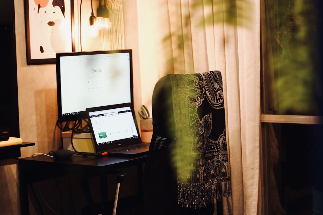 black laptop computer on brown wooden desk