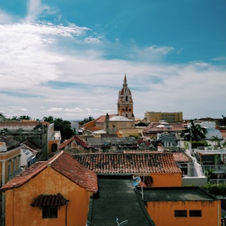 brown and white concrete buildings under blue sky and white clouds during daytime