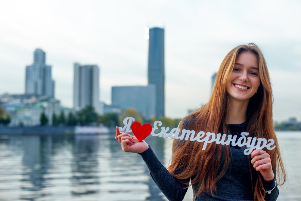 woman in black long sleeve shirt holding red heart