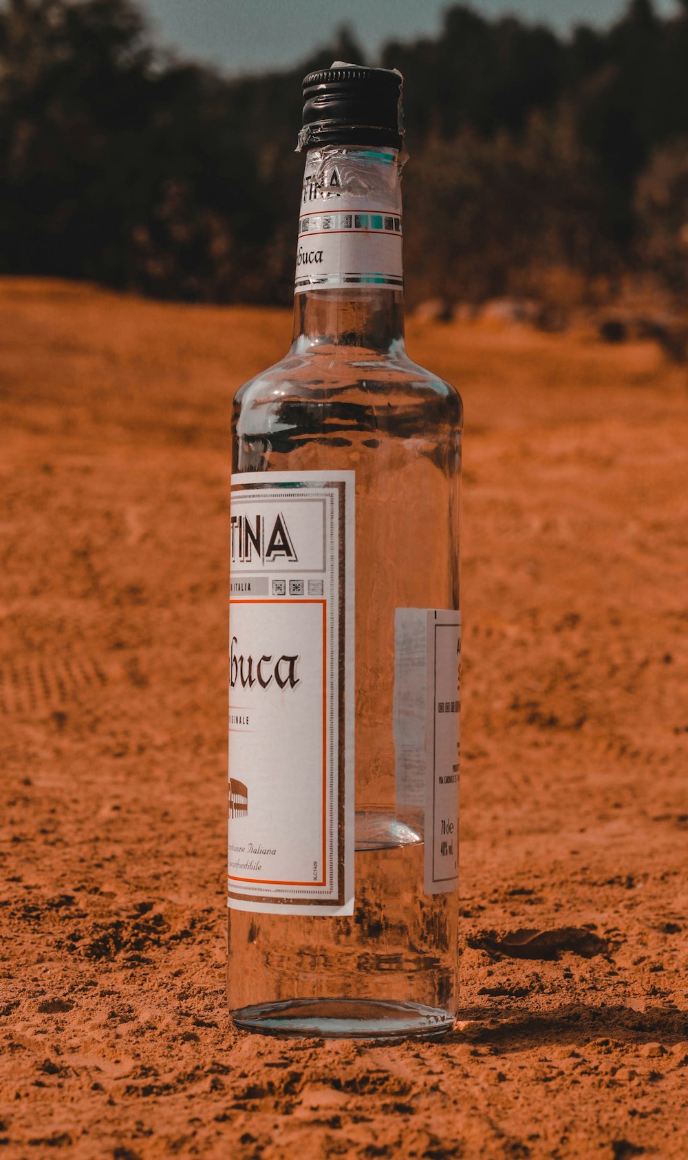 a bottle of alcohol sitting on the ground