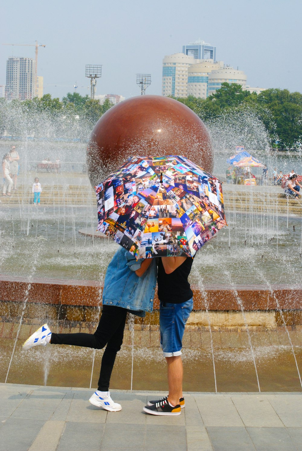 Frau in blauer Jeansjacke in der Nähe des Wasserbrunnens