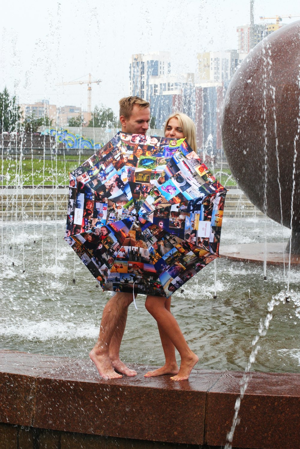 woman in blue yellow and white floral dress standing on water fountain during daytime