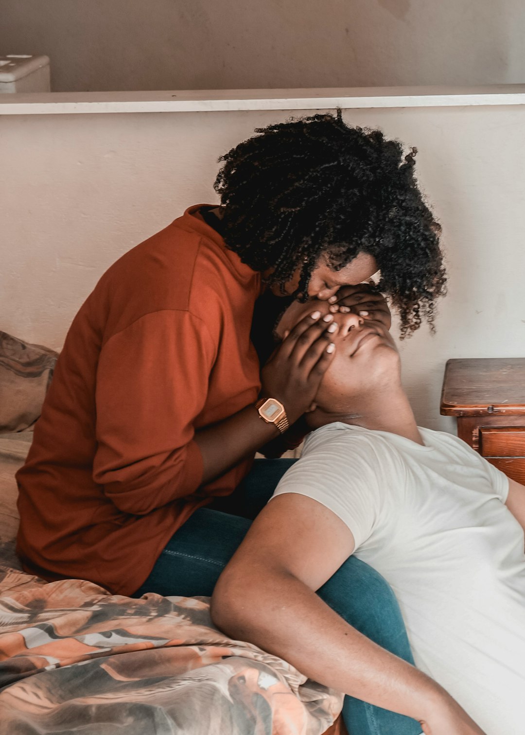 woman in orange shirt sitting on bed