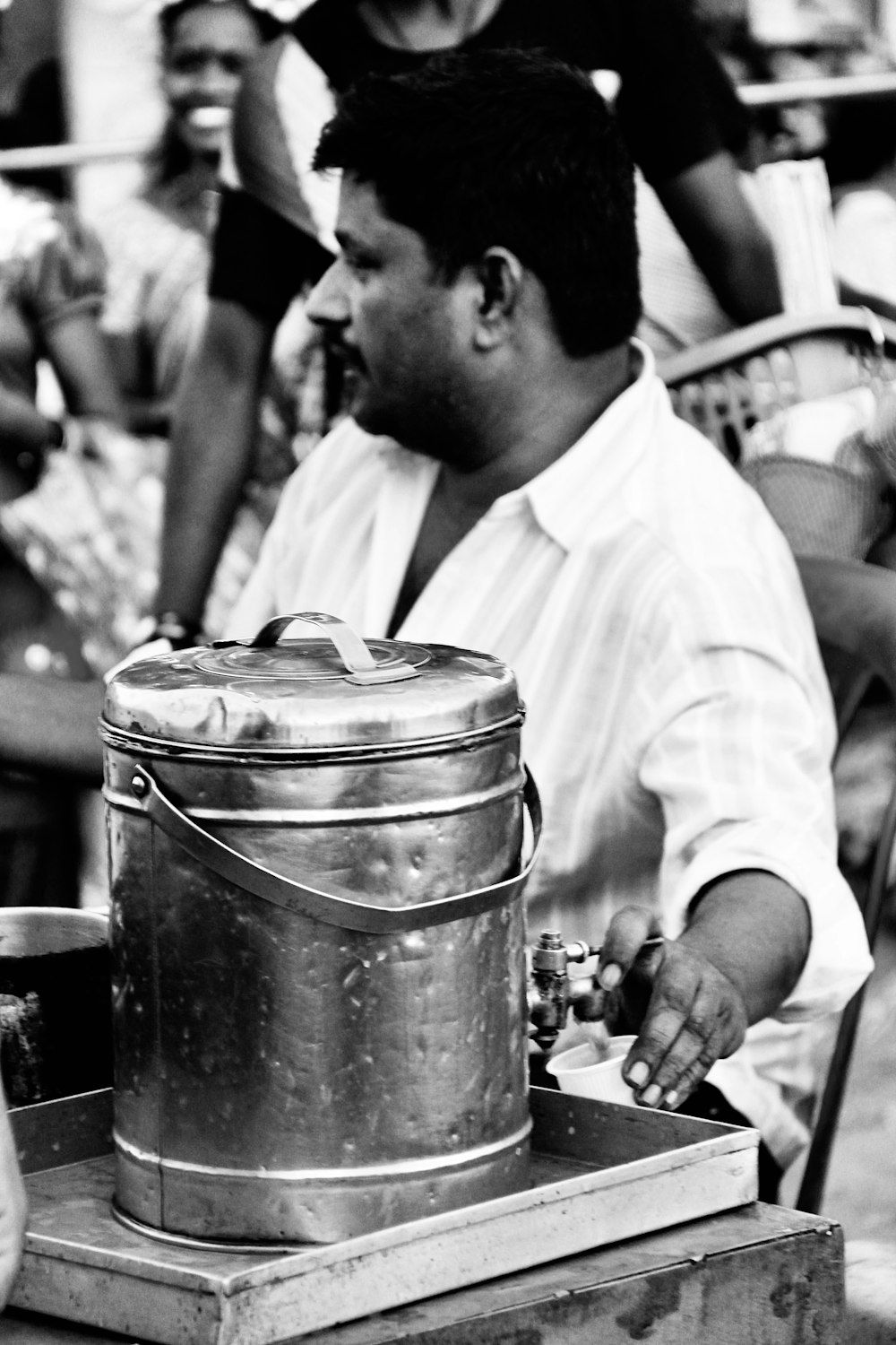 man in white dress shirt holding stainless steel bucket