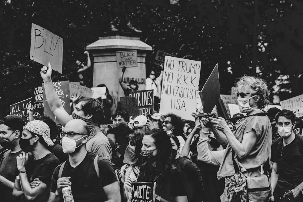 grayscale photo of people holding signage