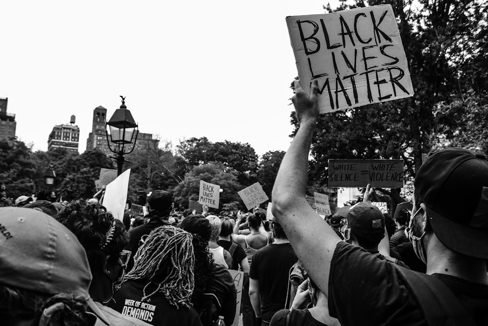 grayscale photo of people holding square board