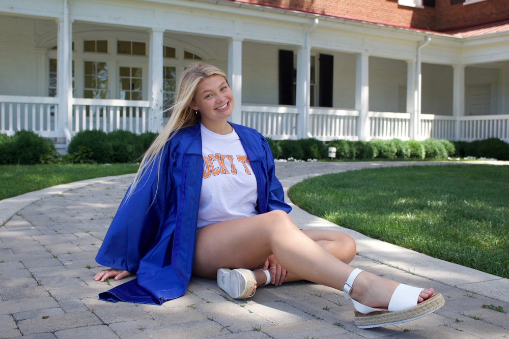 woman in blue and white adidas jersey shirt sitting on brown wooden bench