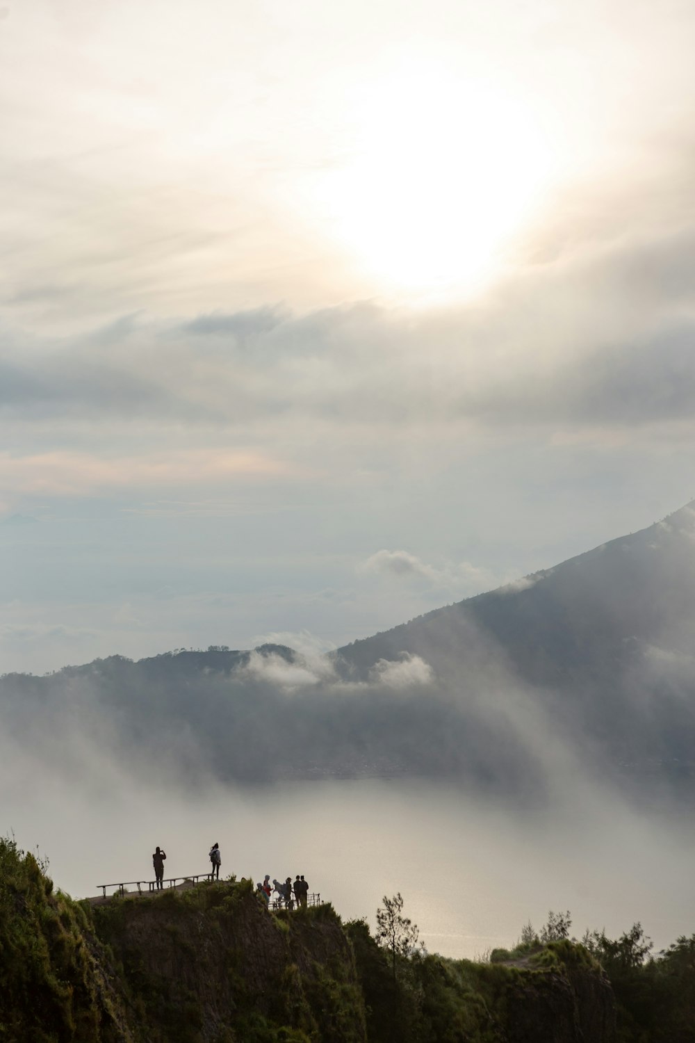 green trees near mountain under white clouds during daytime