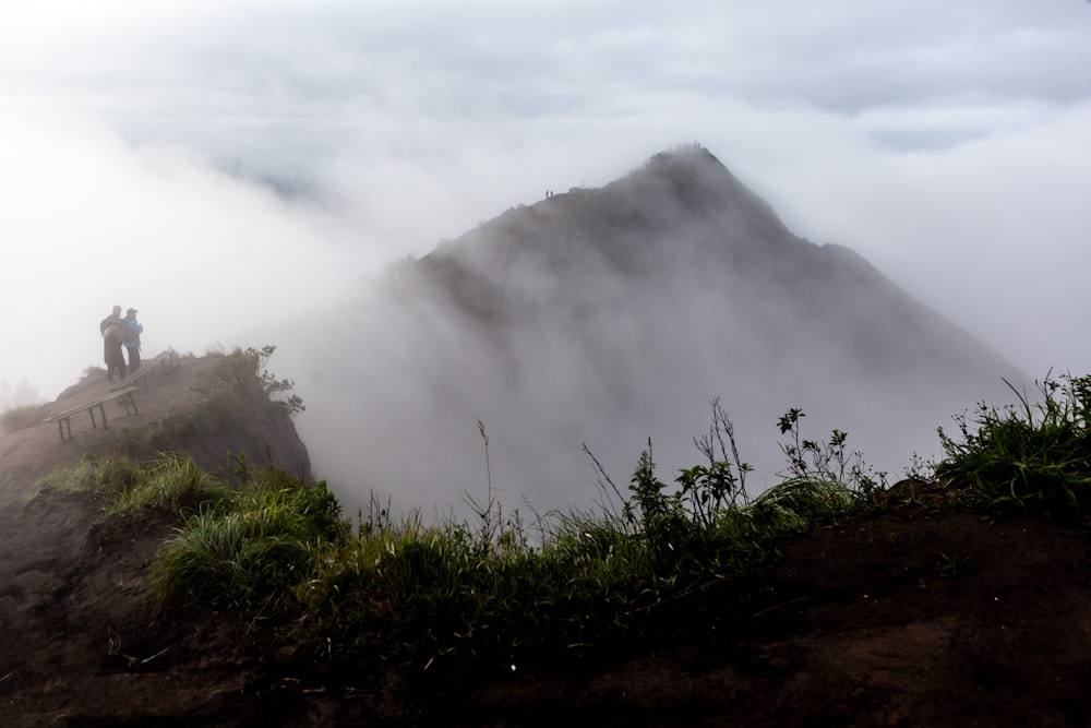 green grass on mountain under white clouds during daytime