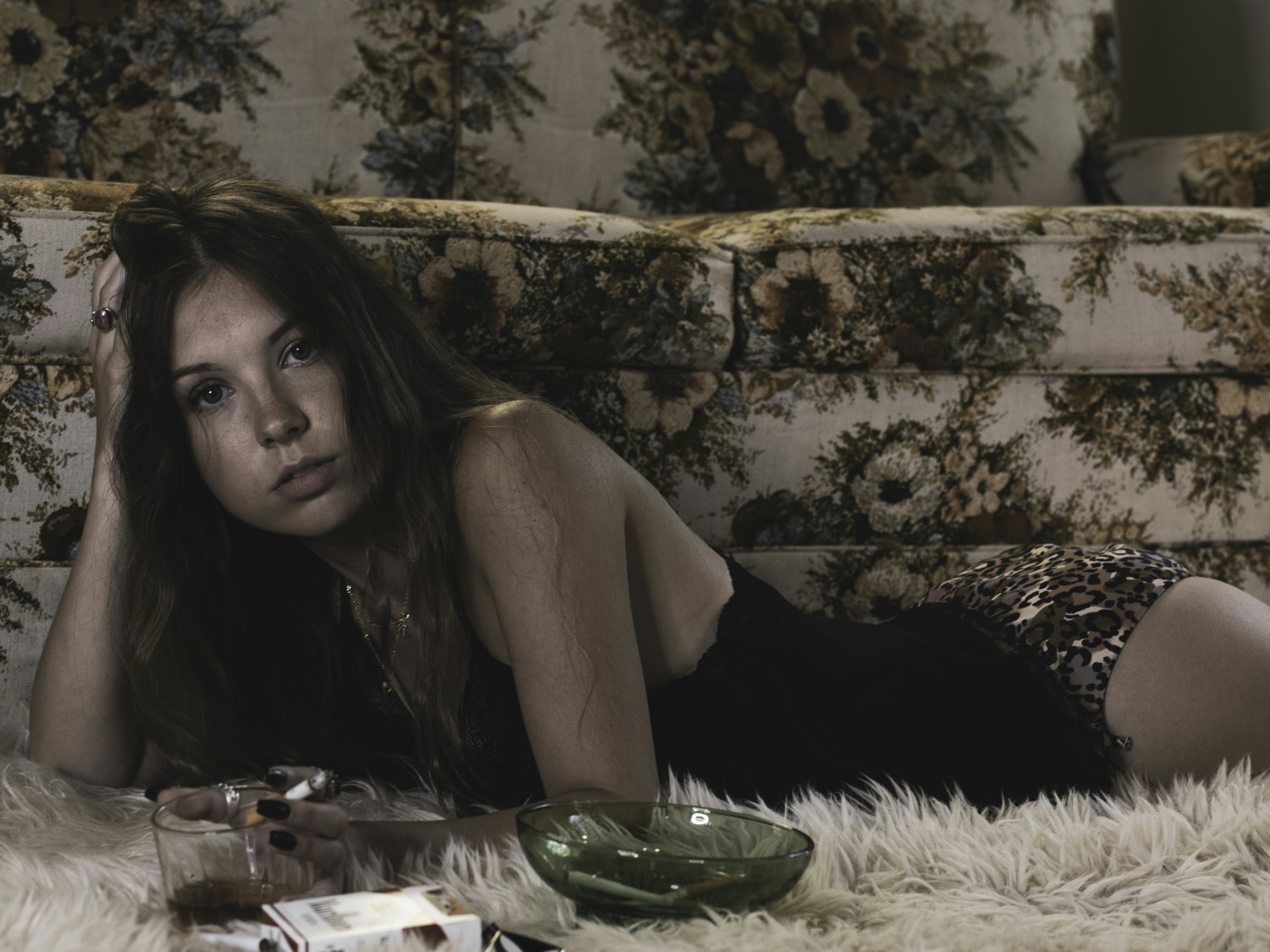 woman in black tank top sitting on brown and black leopard print couch