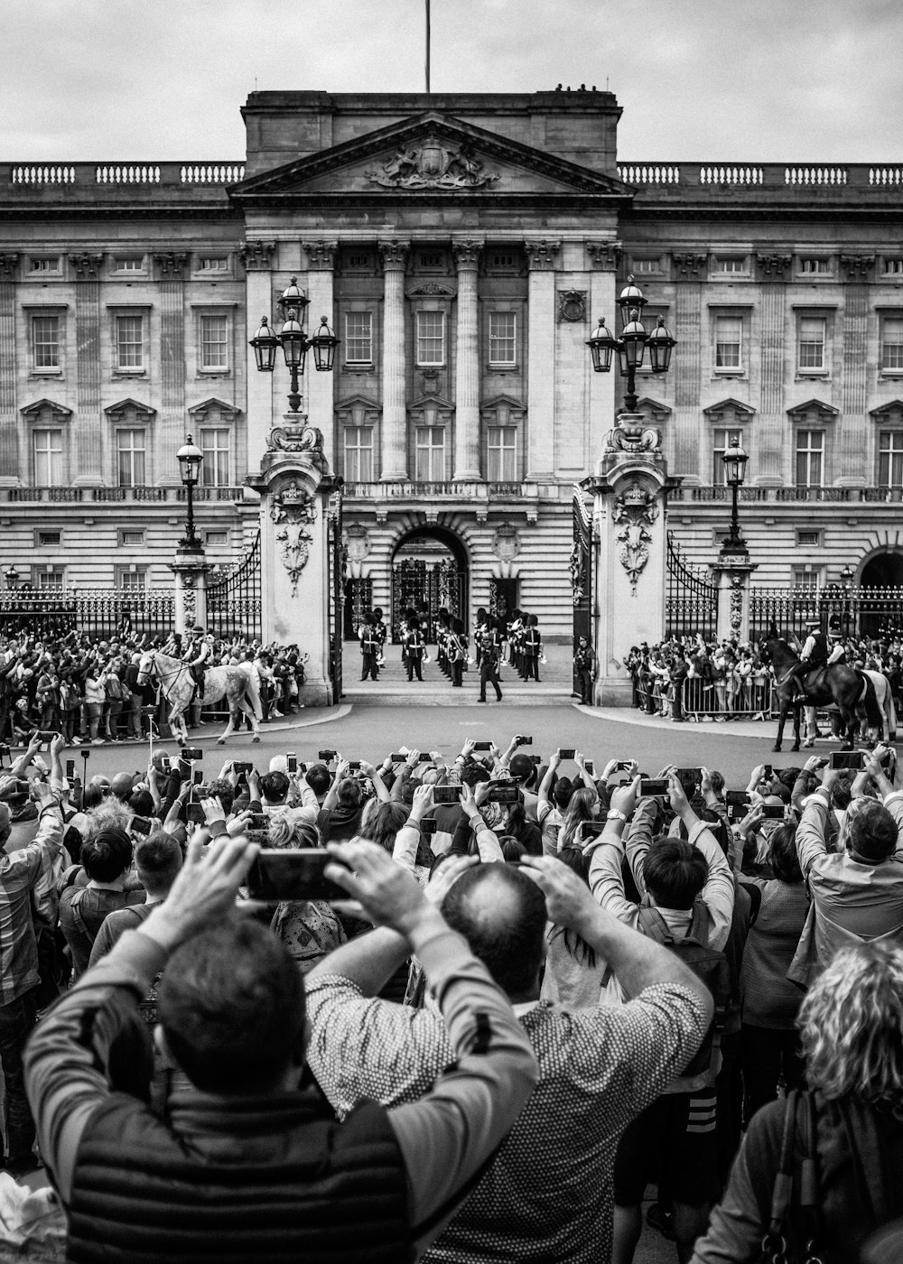 grayscale photo of people in front of building