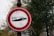 A round traffic sign with a red border against a backdrop of trees and poles. Inside the sign is an image of a hand holding a bottle with the text '% ALC' printed on it.