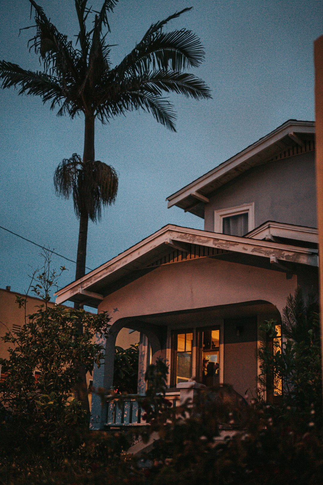 white and brown concrete house near green palm tree during daytime