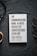 A book titled 'The Communication Book. 44 Ideas for Better Conversations Every Day' by Mikael Krogerus and Roman Tschäppeler is placed on a dark textured surface. There are headphones to the right and a cup on the left.