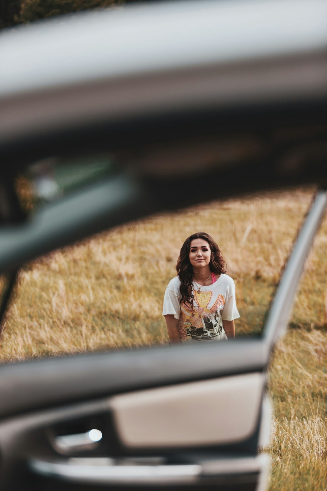 woman in white t-shirt sitting on car