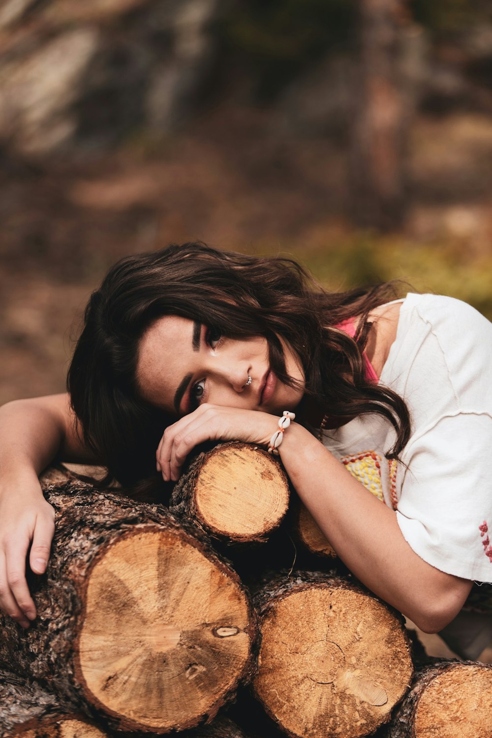 woman in white shirt covering her face with brown log