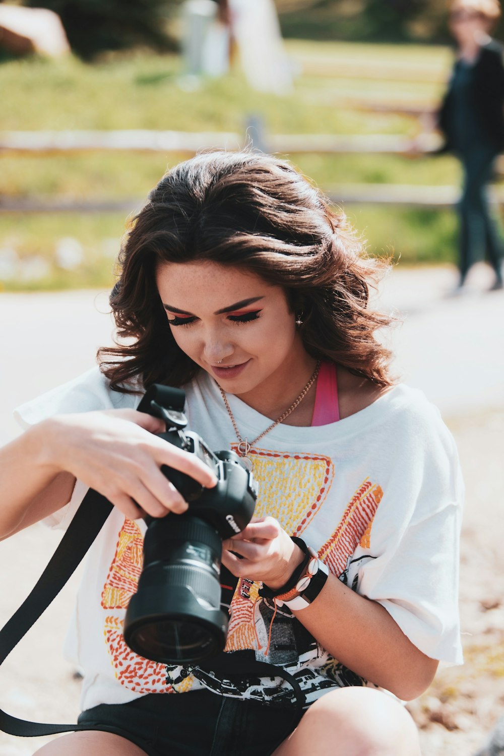 woman in white crew neck t-shirt holding black dslr camera