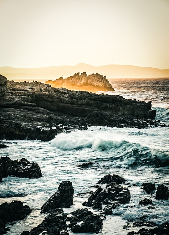 ocean waves crashing on rocks during sunset in Hermanus South Africa