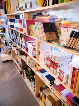 A bright display of colorful notebooks and planners neatly arranged on wooden shelves.