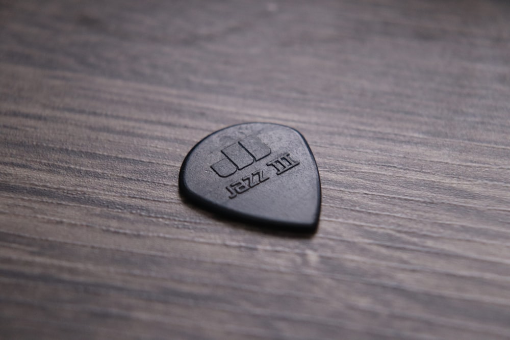 black guitar pick on brown wooden table