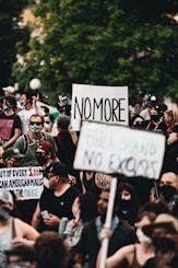people holding white and black signage during daytime