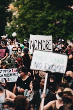 people holding white and black signage during daytime