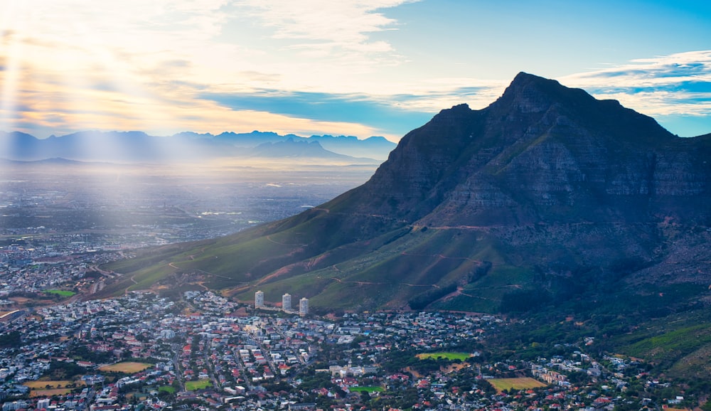 city near mountain under cloudy sky during daytime