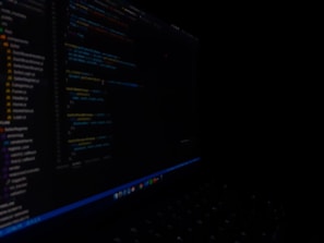 Close-up of a developer coding intense algorithms on a sleek laptop with lines of code glowing in dark mode.